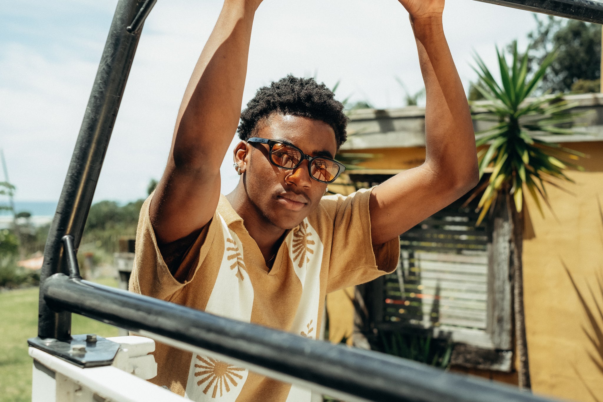 man wearing sunglasses leaning on truckbed